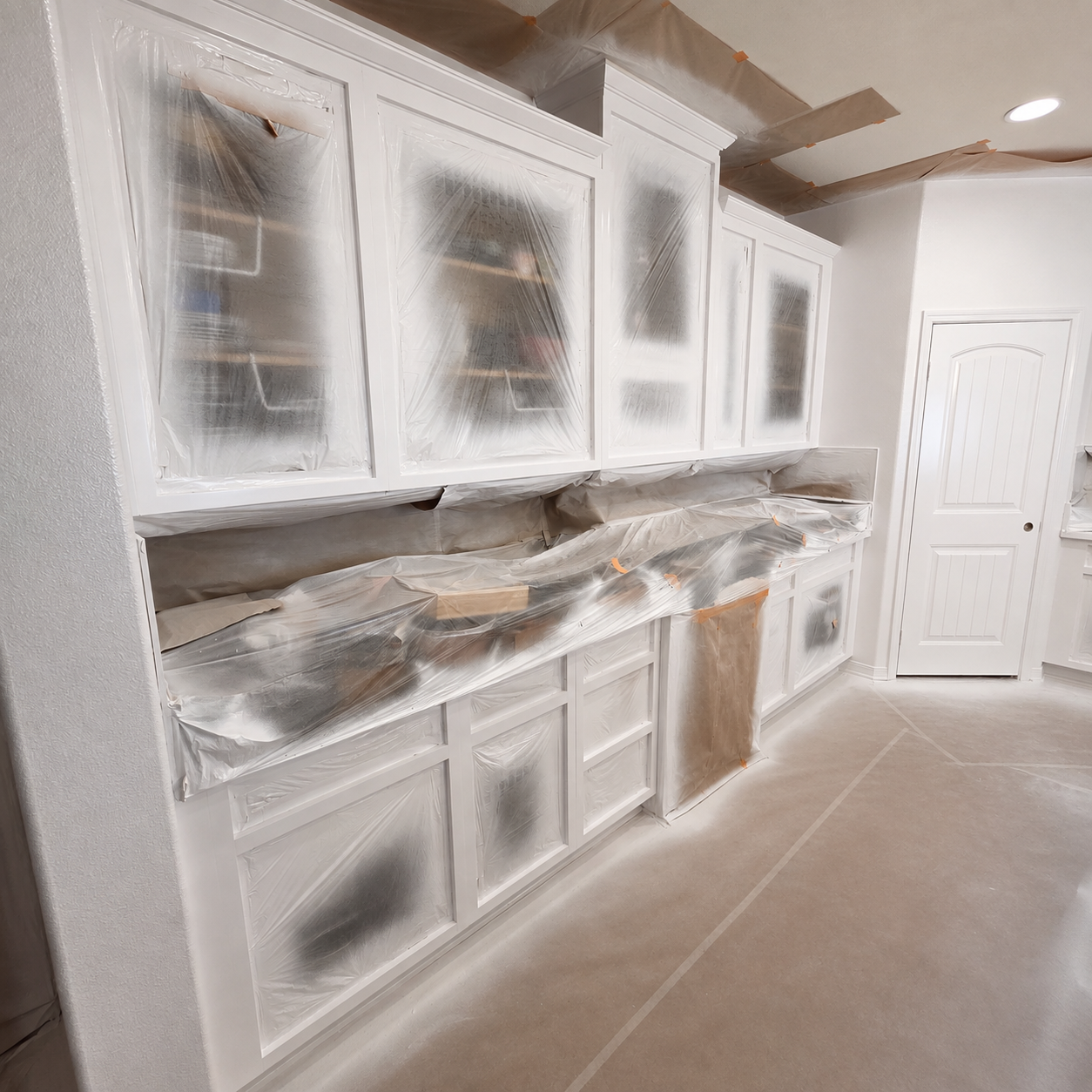 Kitchen cabinets carefully masked and protected for cabinet painting